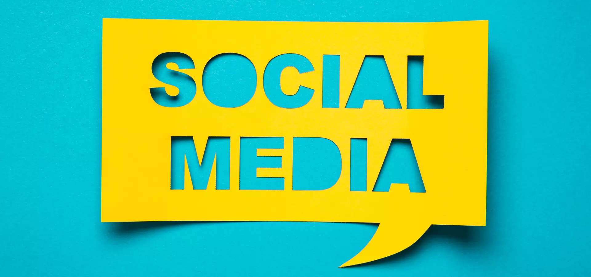 Cut-out yellow sign with the words 'social media' on a blue background.