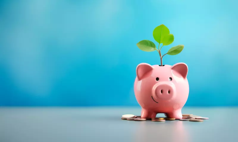 Piggy bank with a plant growing out of it and money in front of it.