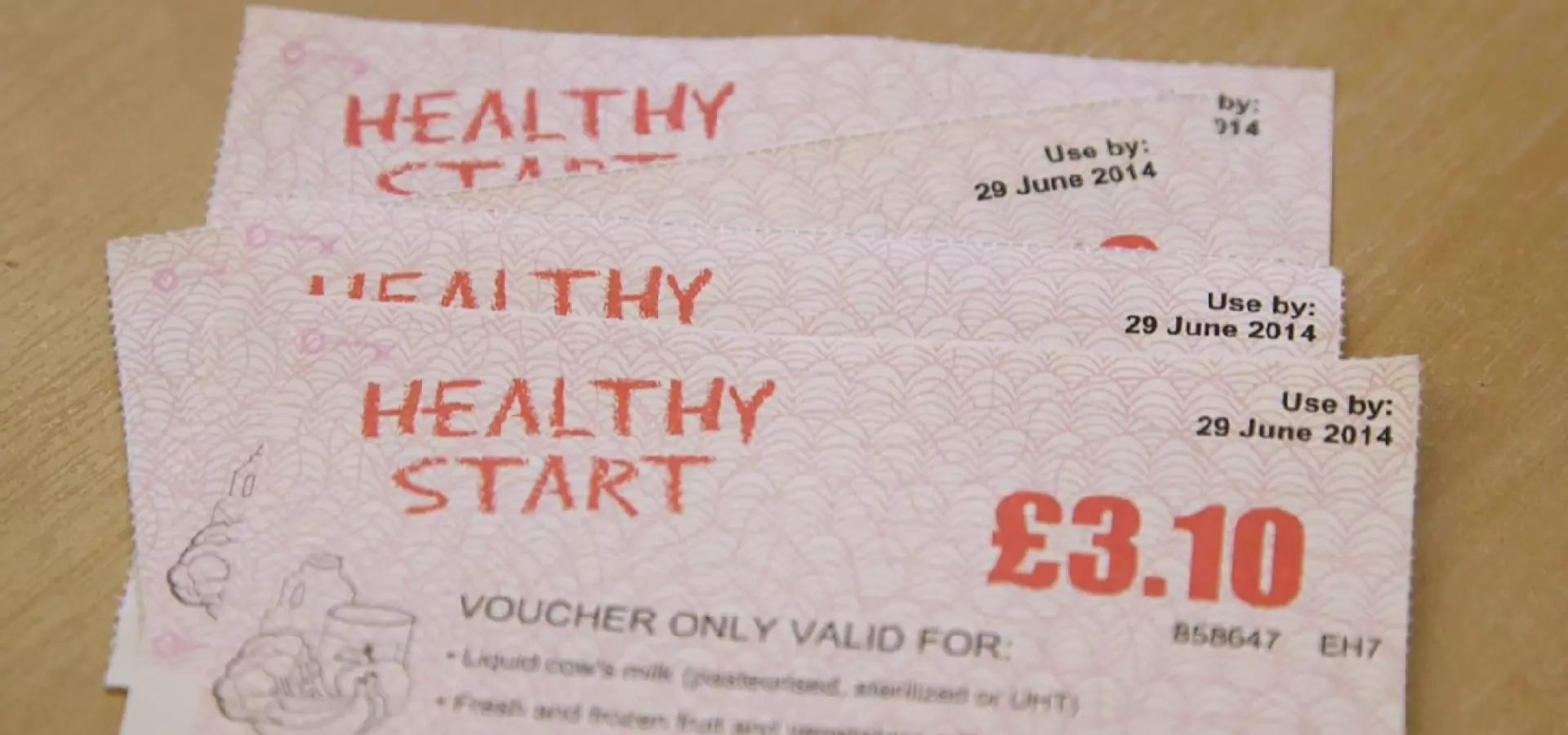 Four Healthy Start vouchers laid out on a table.