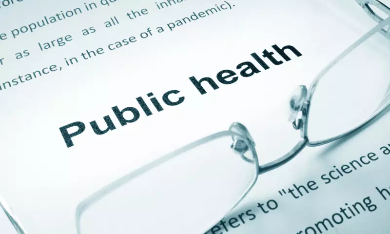 A pair of glasses resting on a journal with the words 'public health' in bold.