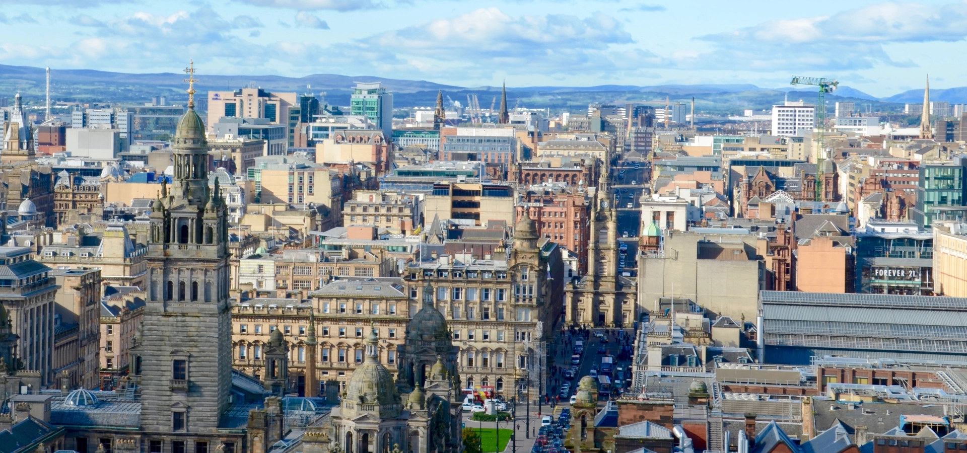 Aerial view of Glasgow with rooftops and the Campsies behind.