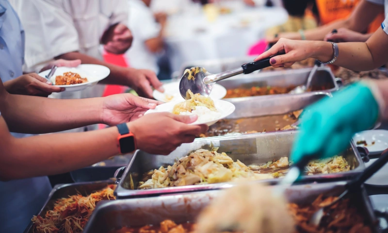 People serving food to community members.