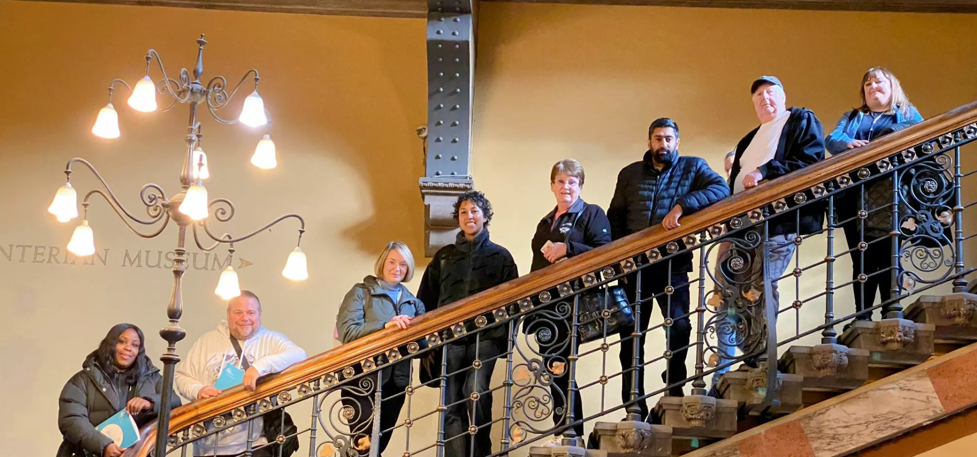 Members of the Lived Experience Panel standing on some stairs, looking at the camera.